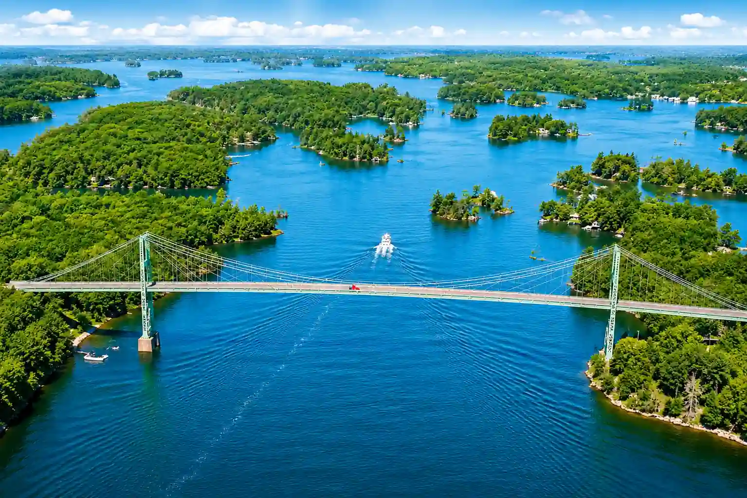 Panoramic view of forested Thousand Islands and the St. Lawrence River from the deck of a sightseeing cruise boat